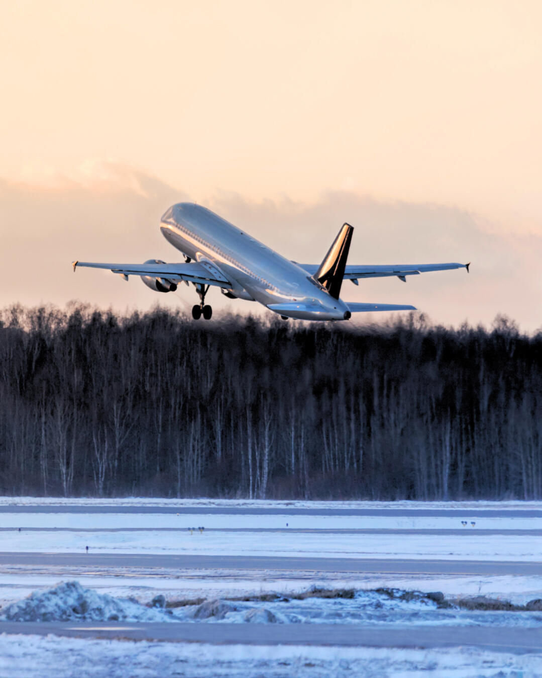 Aviation Operations and Organizational Transformation Commercial aircraft taking off over a snow-covered landscape, reflecting Mie Rajcic's work in aviation leadership, operational reliability, organizational transformation, and safety-critical environments